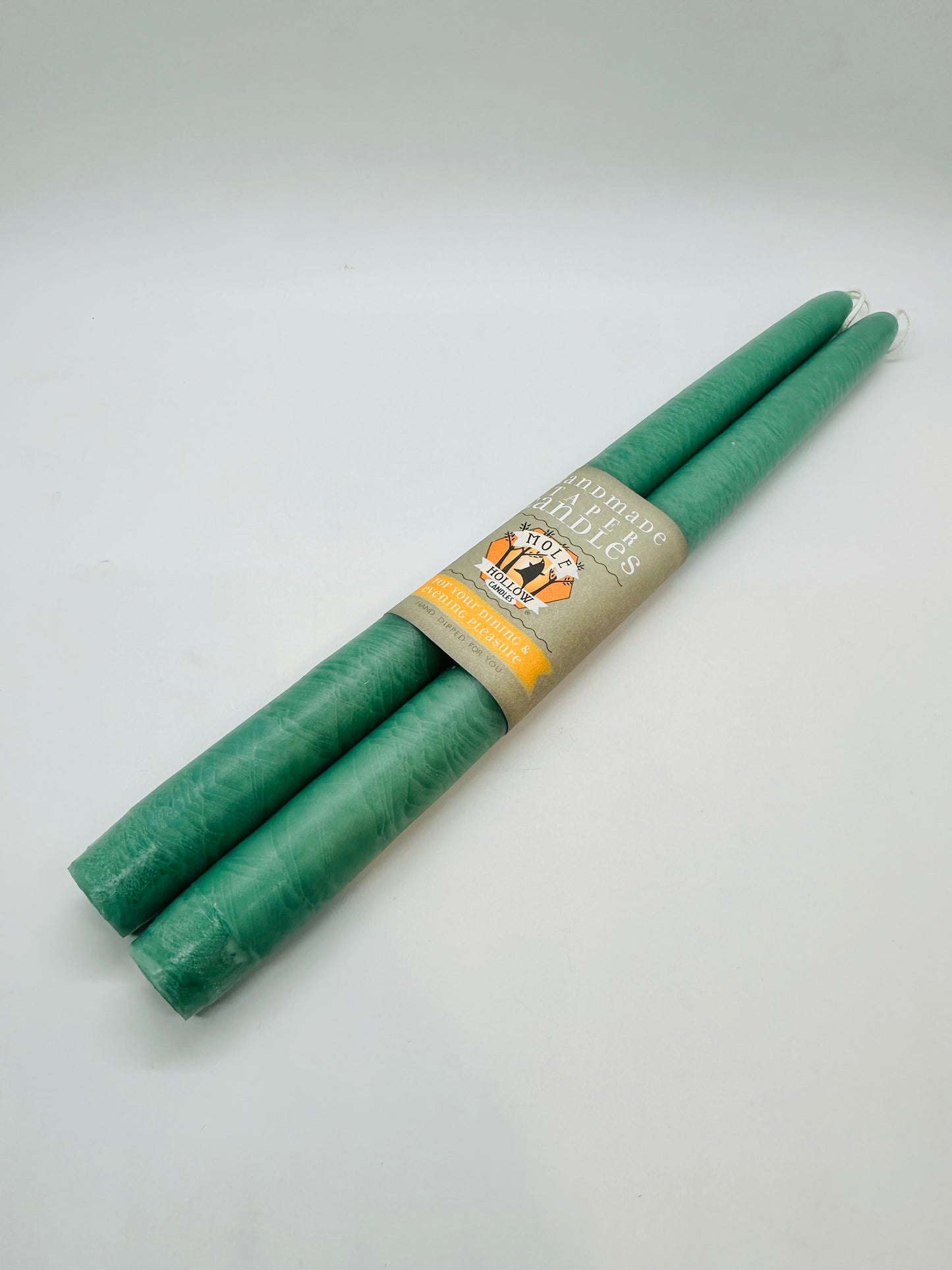 Set of two 12" taper candles in Sea Green with a white packaging featuring branding.