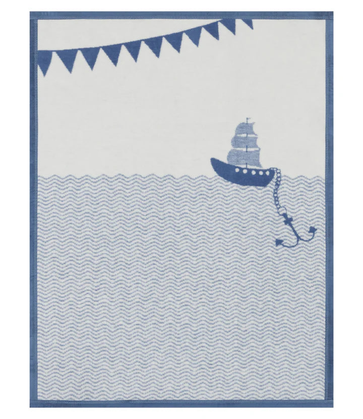 Nautical-themed baby blanket with a ship and banner design in blue and white.