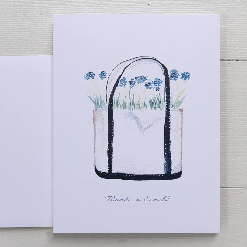 Canvas tote with blue straps filled with blue hydrangeas. text states thanks a bunch