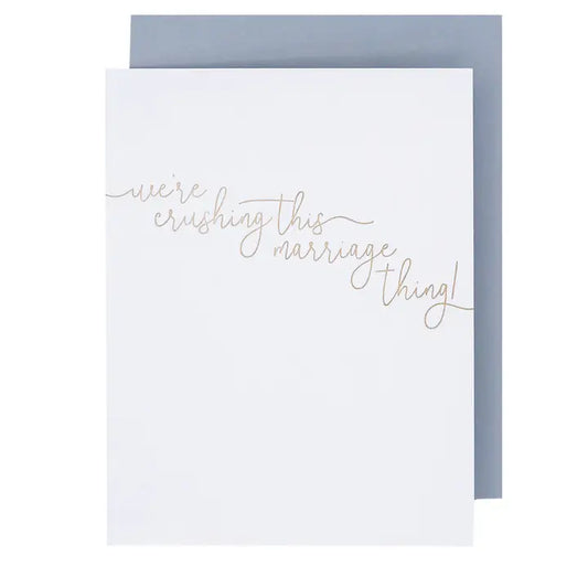 White card with gold cursive words in the middle