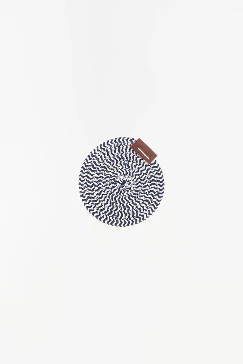 A round placemat with a blue and white rope pattern