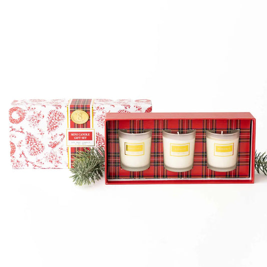 Set of three candles in a decorative box with a red plaid pattern on a white background