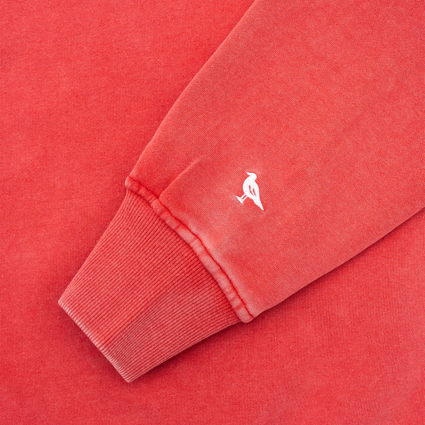 Close-up of a red sweatshirt with a small white Just Brand Seagull on a matching red background
