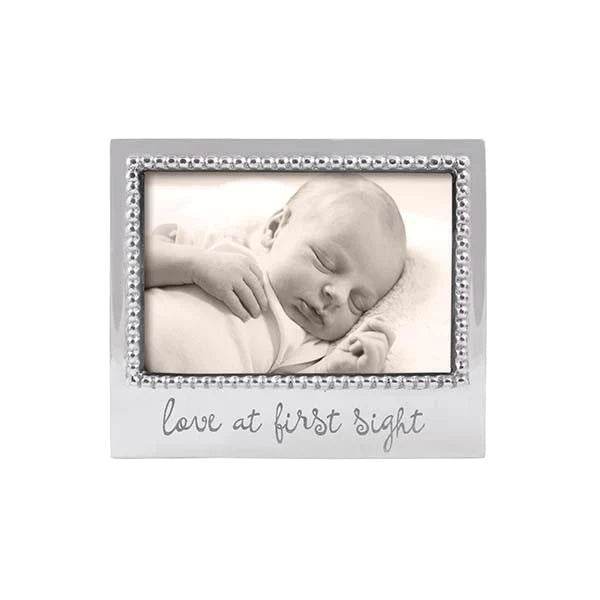 Silver frame with beaded edge. Love at First Sight is engraved on the bottom center in script font