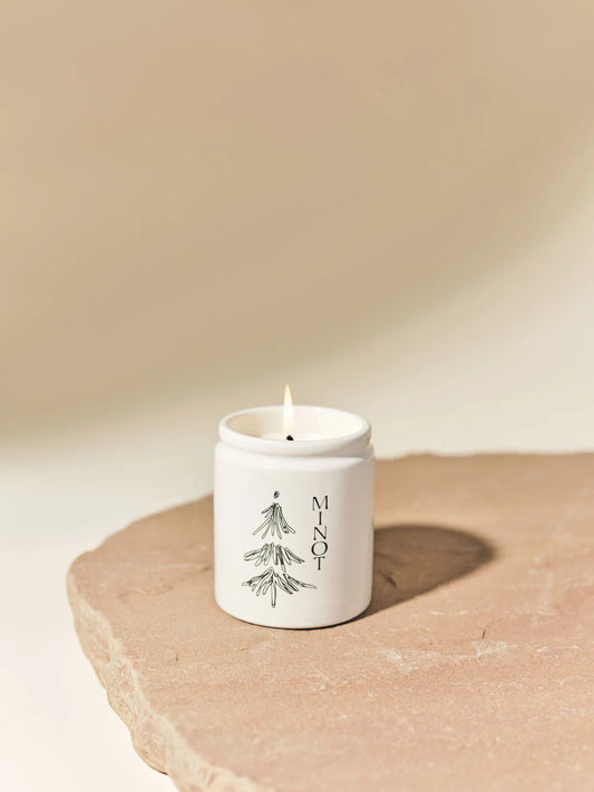 Ceramic Candle with the image of a tree in black.  and the word  Minot vertical