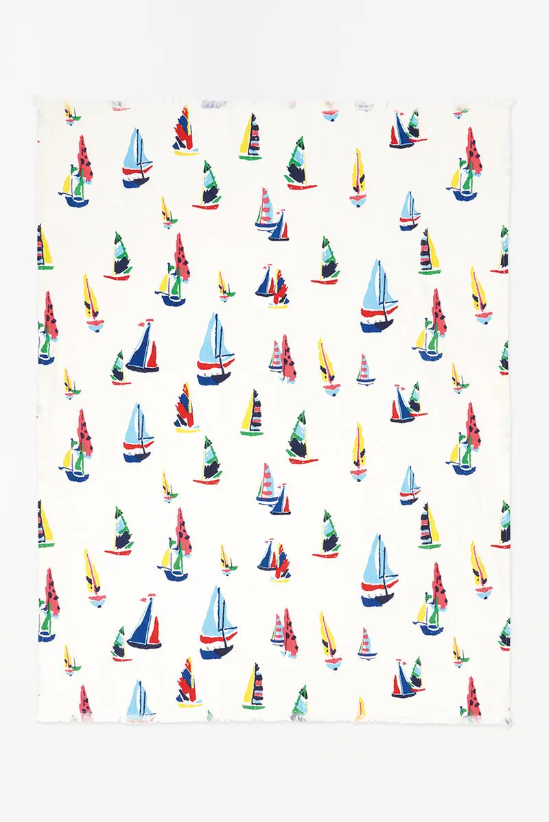 White cotton blanket with different colored and sized sailboats