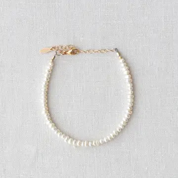 Pearl bracelet on a light gray fabric background