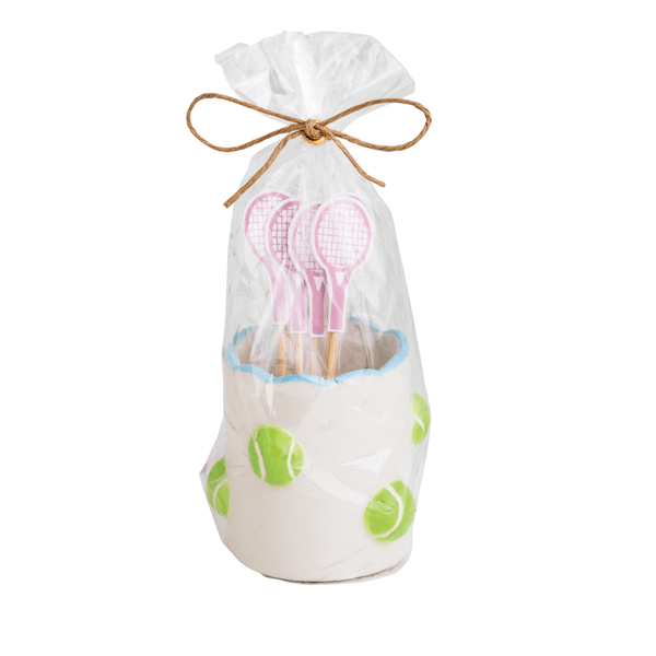 Toothpick holder with pink tennis racket picks in a scalloped edge white ceramic holder with tennis balls scattered on it in a clear cello bag tied with twine