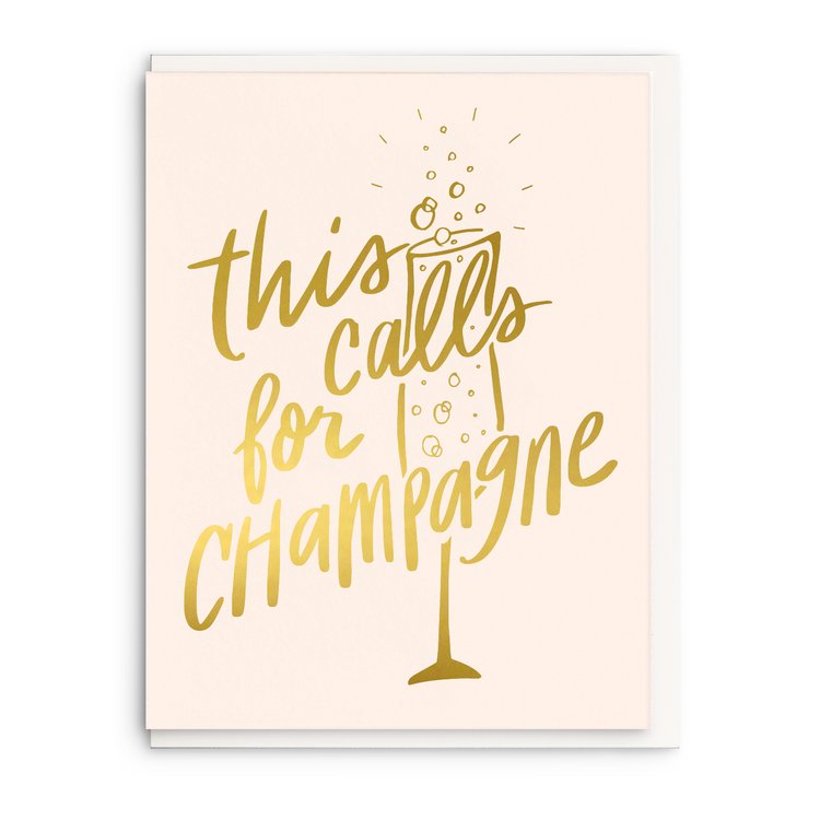 White celebration card that has a gold champagne glass and gold lettering on it.