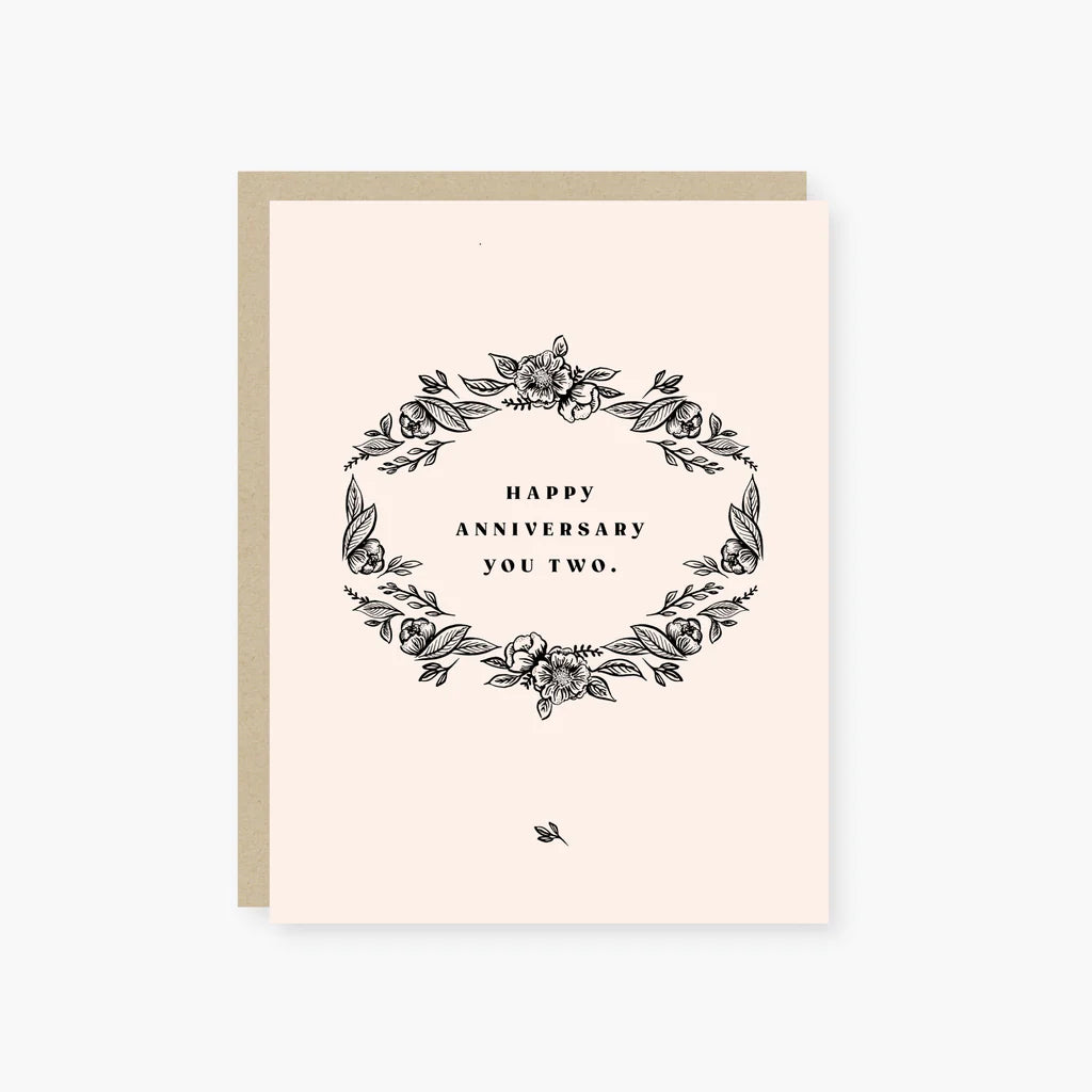 Greeting card with floral design and 'Happy Anniversary You Two' text on a light pink background