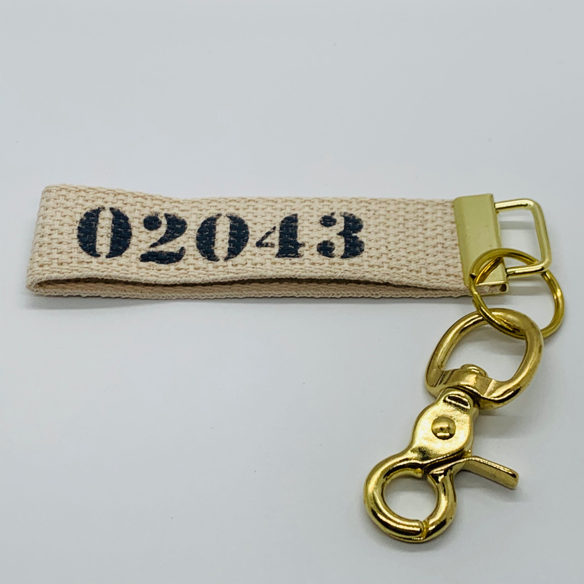 02043 Key chain with navy writing and gold touches and a white canvas background