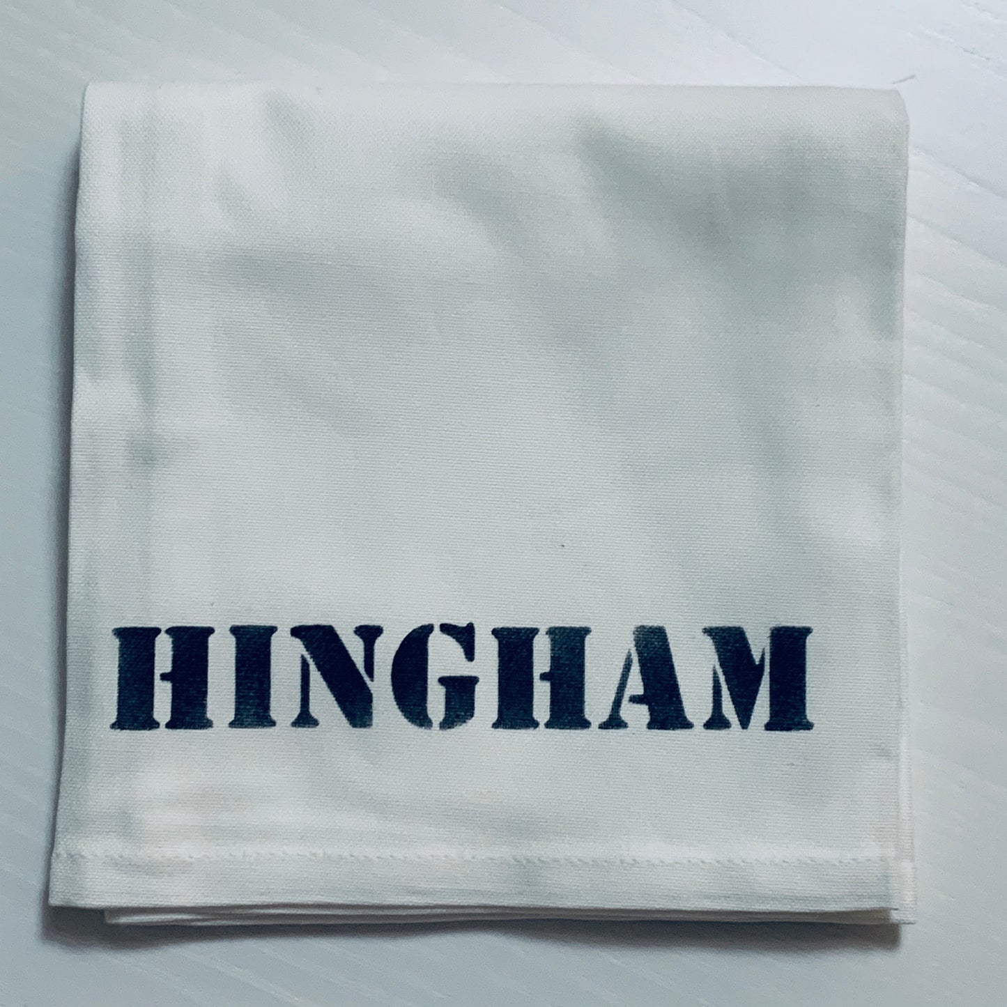 Hingham Tea towel that is white with navy blue writing