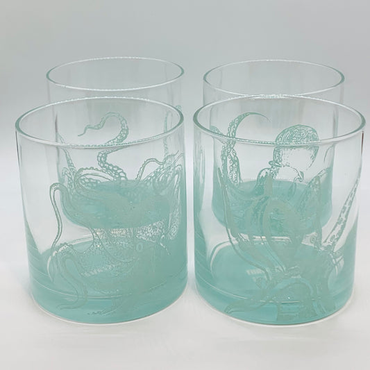Teal and clear glasses with octupi on them and a teal base