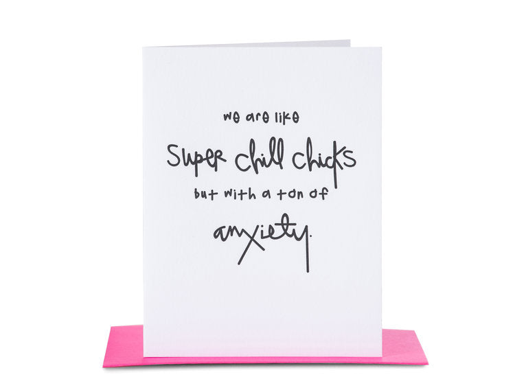 A folded white greeting card with black hand-printed text and paired with a neon pink envelope.
