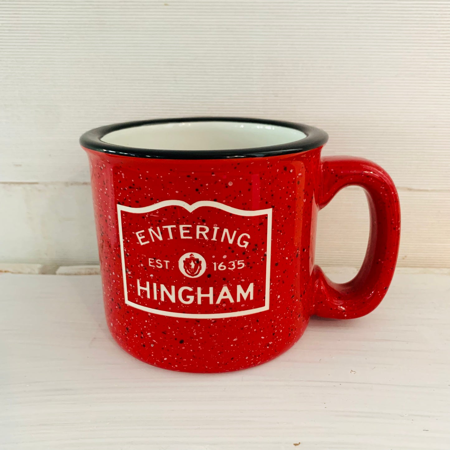 A red ceramic camp style mug with a speckled pattern and the text 'ENTERING HINGHAM EST. 1654' printed on it.