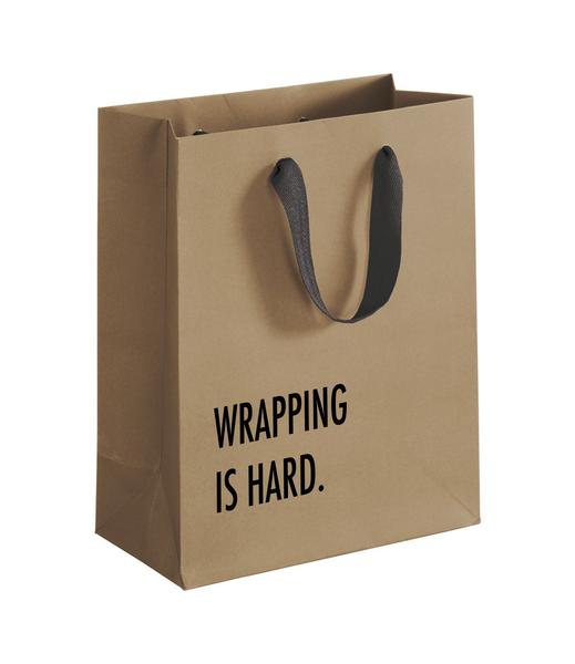 Brown gift bag with black touches that says "Wrapping is hard"