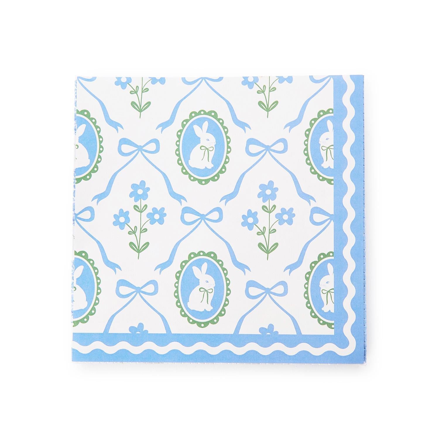 Patterned paper cocktail napkins with blue and green bunnies and bow design on a white background