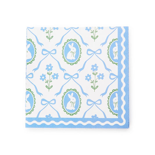 Patterned paper cocktail napkins with blue and green bunnies and bow design on a white background