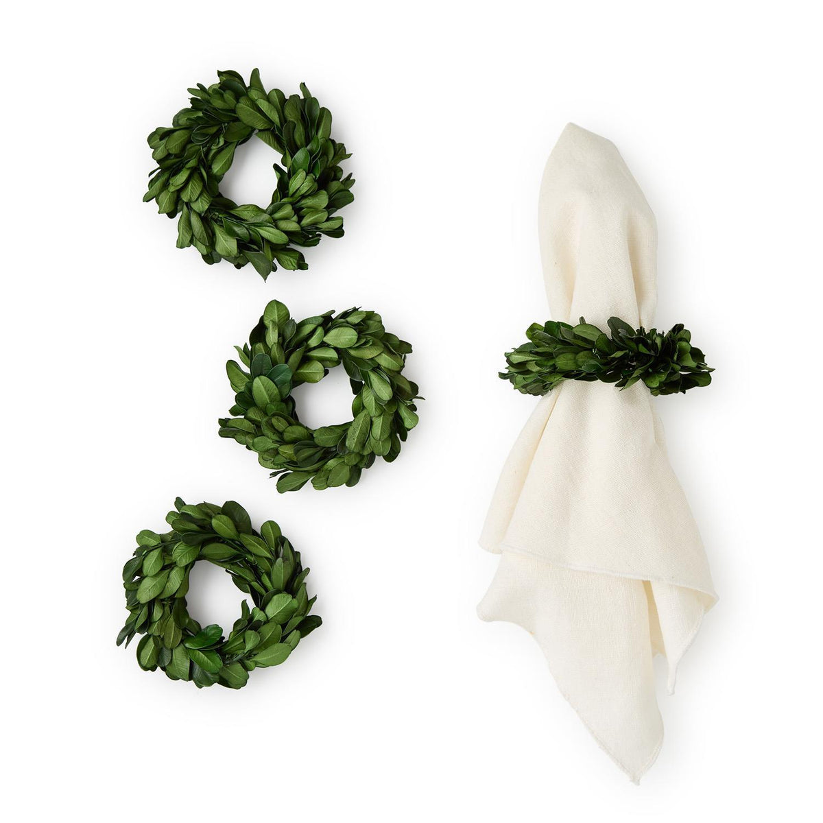 Boxwood wreaths napkin holder and a white napkin on a white background