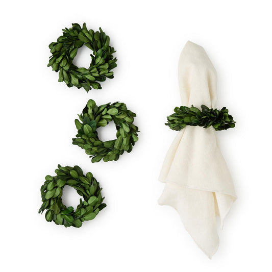 Boxwood wreaths napkin holder and a white napkin on a white background
