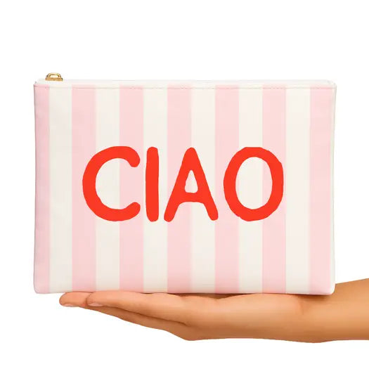 Pink and white striped clutch with 'CIAO' text held in a hand on a white background