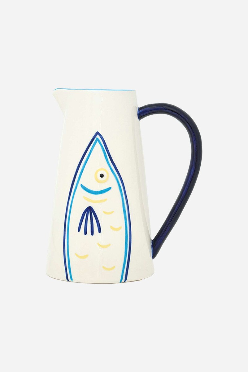 Ceramic pitcher with blue and yellow fish design on a white background and a blue handle