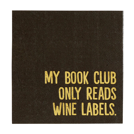 A black cocktail napkin with metallic gold accents and the text 'MY BOOK CLUB ONLY READS WINE LABELS.'
