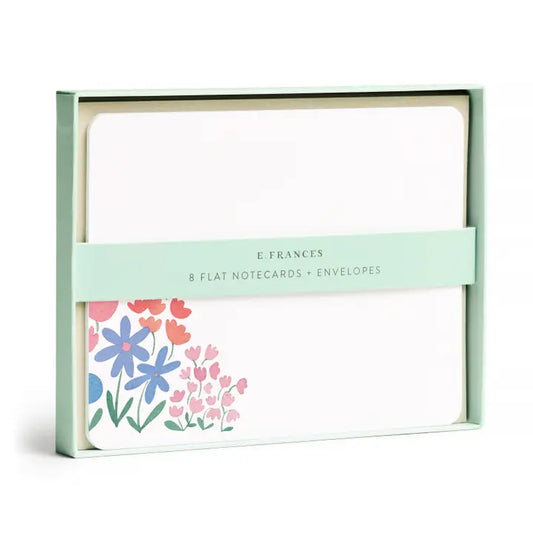 Box set of eight, flat E. Frances notecards and envelopes featuring a sweet, colorful floral patch in pink and lavender colors in the lower left-hand corner of the notecards.