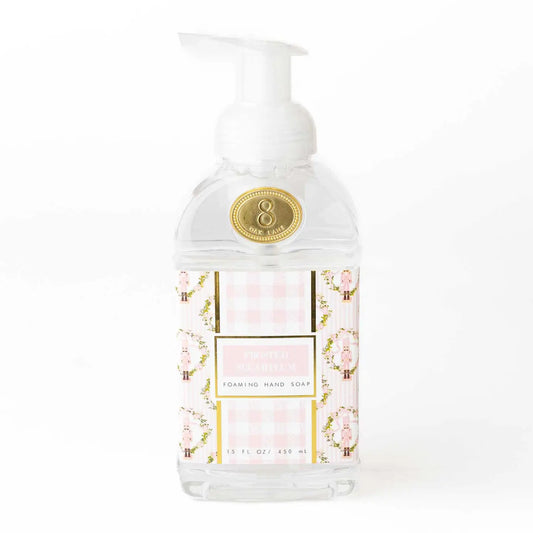 Frosted Sugarplum scented foaming hand soap in a clear plastic pump bottle, decorated in pink and white florals, with gold accents and repeating Nutcrackers. 