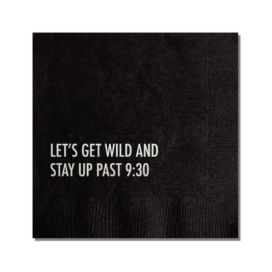 A black cocktail napkin with the text 'LET'S GET WILD AND STAY UP PAST 9:30' printed in silver.