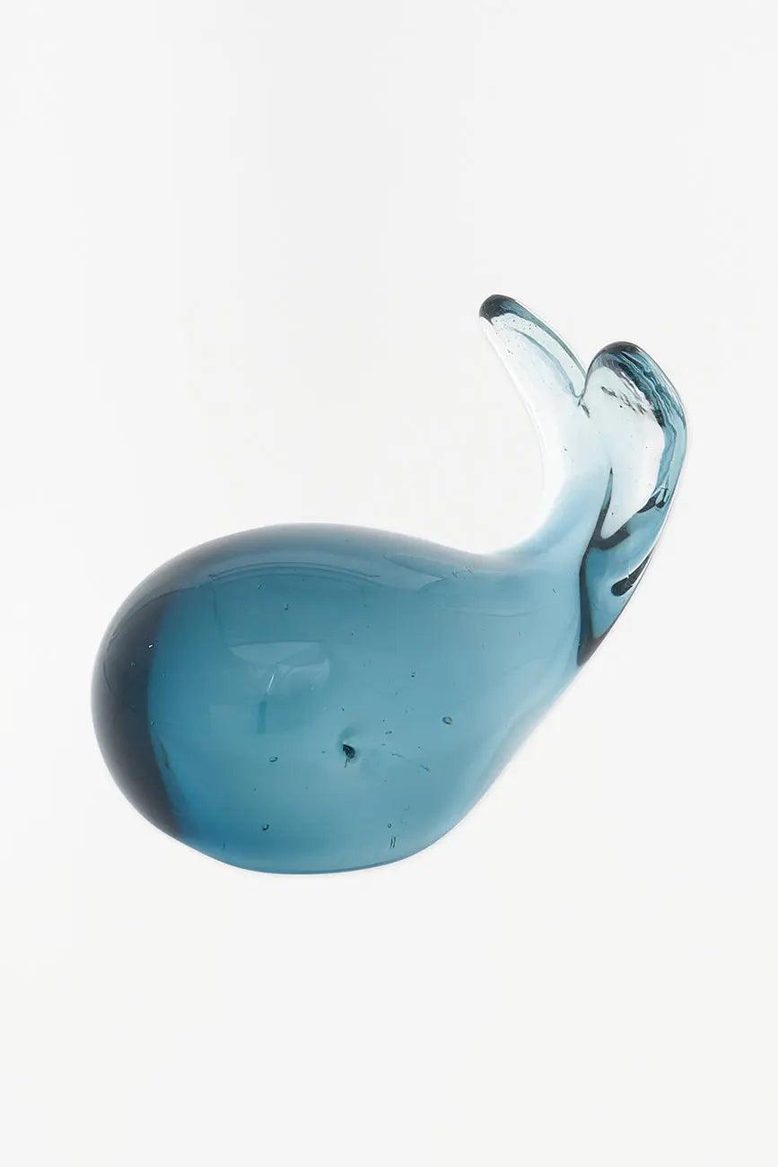 A blue glass sculpture in the shape of a whale with a transparent belly