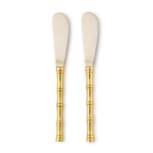 Two spreader knives with gold handles on a white background