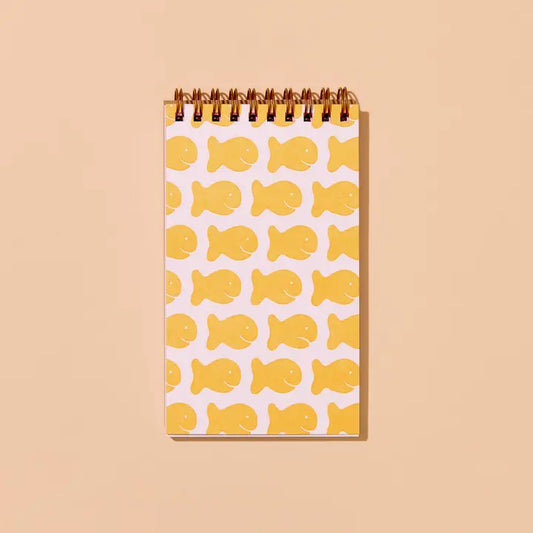Spiral notebook with yellow fish pattern on a white background