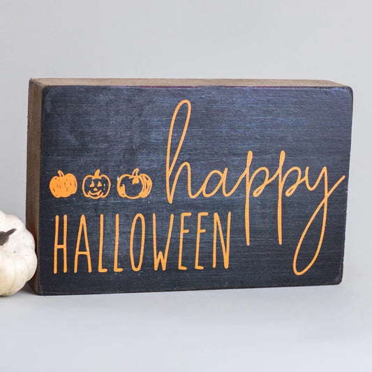 wooden block with black background and happy halloween in orange writing