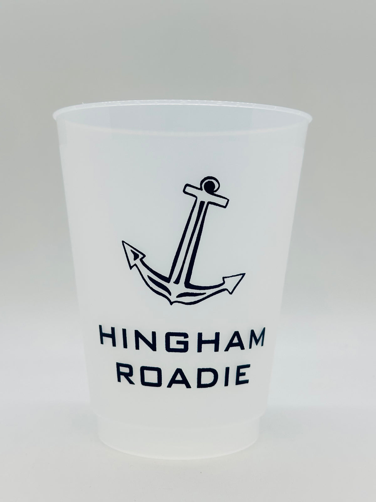 A shatterproof white cup with navy print text reading 'HINGHAM ROADIE' and a anchor graphic.
