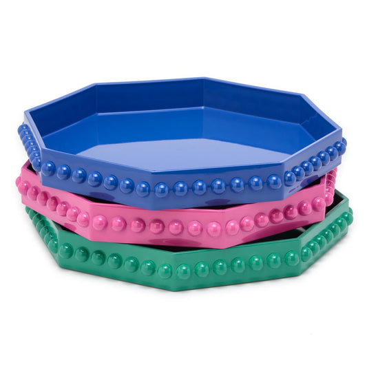 A stack of three octagonal trays in blue, pink, and green colors with a geometric design around the edge.