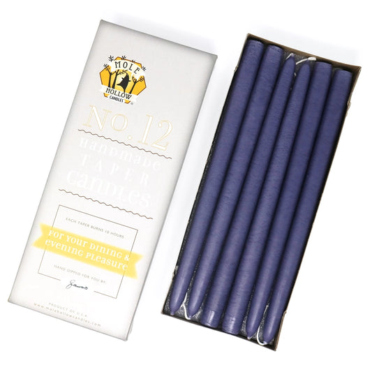Set of two purple taper candles with a white packaging featuring branding.