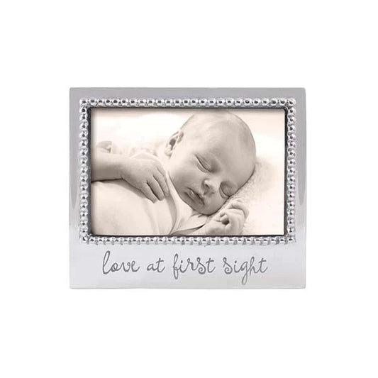 Silver frame with beaded edge.  Love at First Sight is engraved on the bottom center in script font