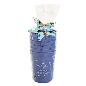 set of six navy blue plastic party cups with "four score & seven beers ago" printed on them in a clear cello bag tied with metal light blue star shaped bottle opener and twine