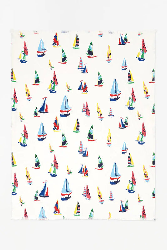 White cotton blanket with different colored and sized sailboats 