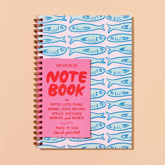 A spiral-bound notebook with white and blue sardines, displayed on the cover.