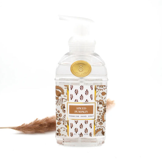 Foaming hand soap bottle of spiced pumpkin with decorative label of fall flowers on a white background