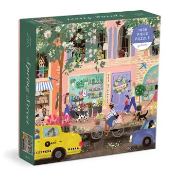 Gallison 1000 piece puzzle is a cheerful, fun springtime street scene featuring flowering trees and capturing everyday moments by artist Joy Laforme