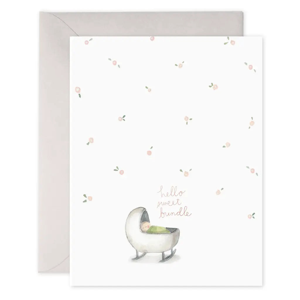 Baby greeting card that reads "Hello sweet bundle' in pink with an illustration of a baby in a cradle and light pink roses scattered throughout
