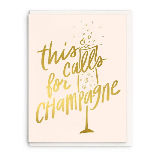 White celebration card that has a gold champagne glass and gold lettering on it.