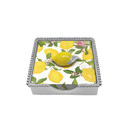silver napkin box with napkins in it that have lemons on them 