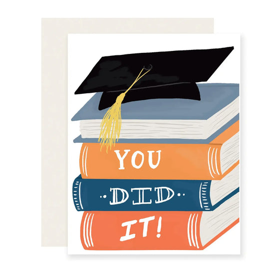 Graduation greeting card with grad cap on top of a stack of books with text on each that reads "you did it" 