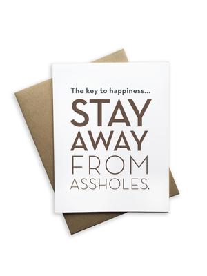 white card with 'the key to happiness stay away from assholes' on front in tan color