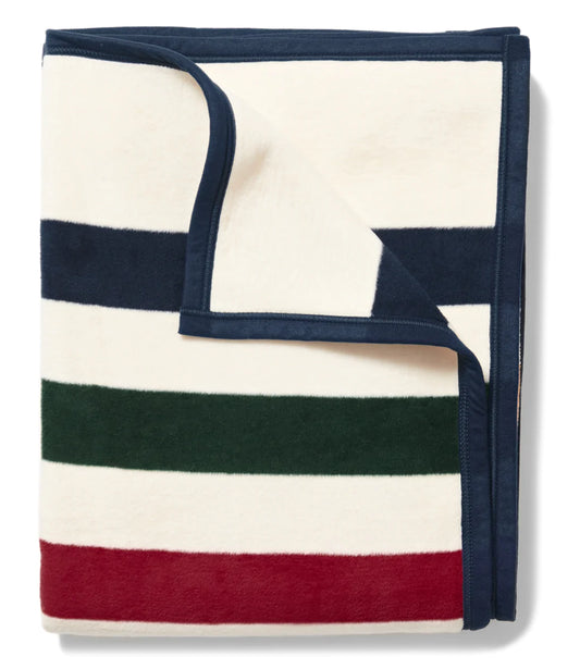 Folded cream color blanket with bold stripes in Navy, Dark Green, Cranberry Red