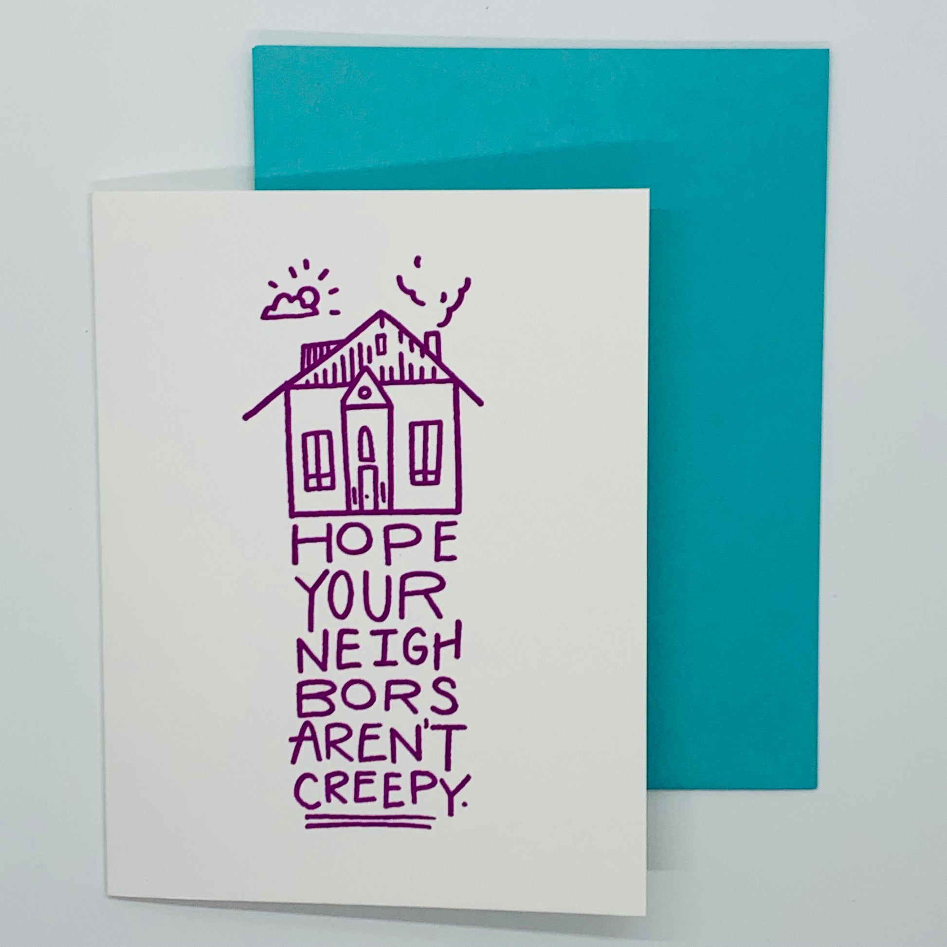 White greeting card that states 'Hope your neighbors aren't creepy'  with teal envelope